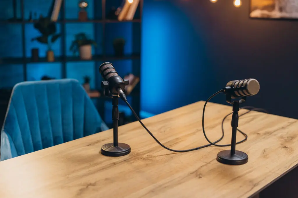 Podcast setup with microphones on wooden table.